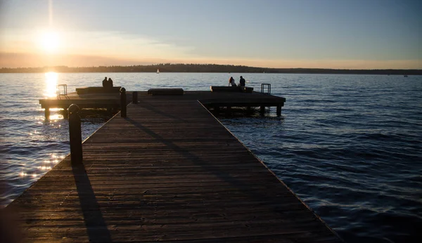カークランド公園木製の桟橋に座ってカップル — ストック写真