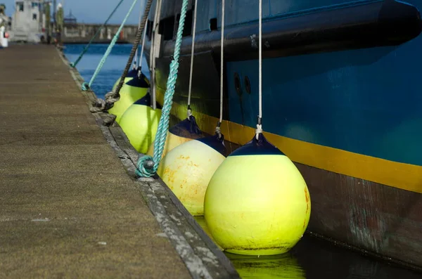 Row Large Yellow Boat Fenders Next Blue Boat Anchored Westhaven — Stock Photo, Image