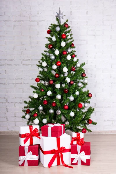 Gedecoreerde Kerstboom Met Kleurrijke Ballen Geschenken Witte Bakstenen Muur — Stockfoto