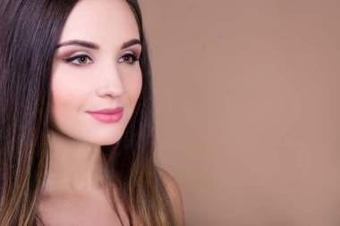 Doğal güzellik konsepti - bej arka planda genç güzel bir kadının portresi