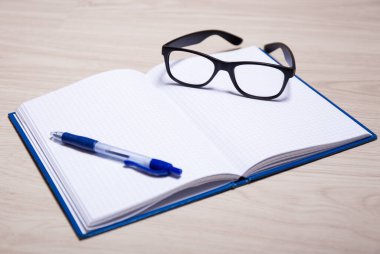 işletme veya eğitim kavramı - masadaki defter, kalem ve gözlük