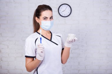 Beyaz tuğla duvarın üzerinde diş fırçası ve model tutan dişçi kadının portresi.