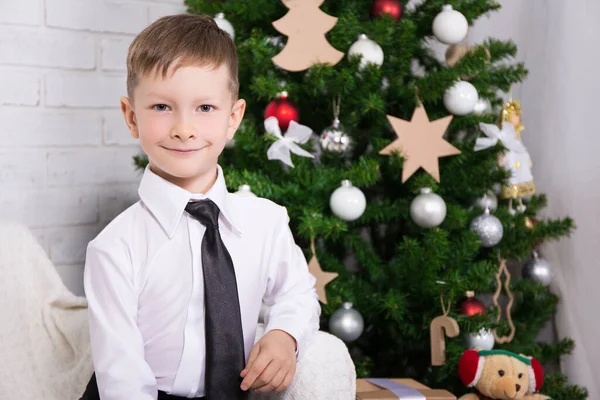 可爱的小男孩坐在装饰了圣诞树的客厅里 — 图库照片