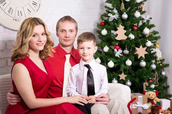 クリスマスツリーの前で幸せな若い家族 — ストック写真