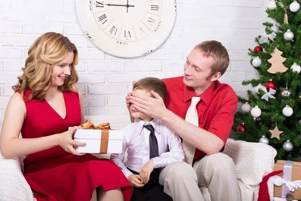 惊喜的概念 父母在圣诞树前送给他们快乐的儿子礼物 — 图库照片