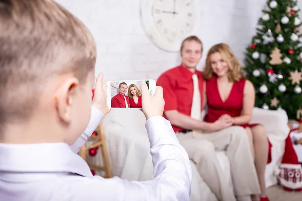 家庭与圣诞概念 小男孩在圣诞树前给他的父母拍照 — 图库照片
