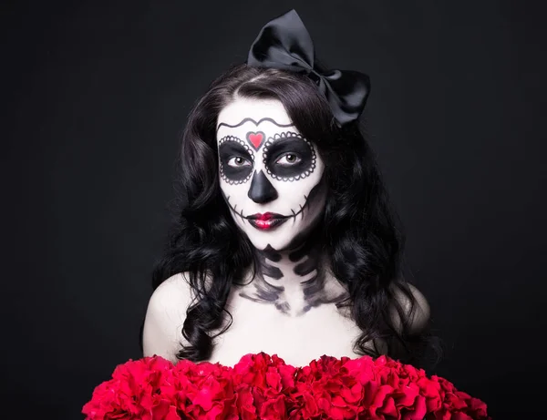 創造的なハロウィーンの頭蓋骨を持つ女性の肖像画は 黒の背景に赤い花を構成します — ストック写真