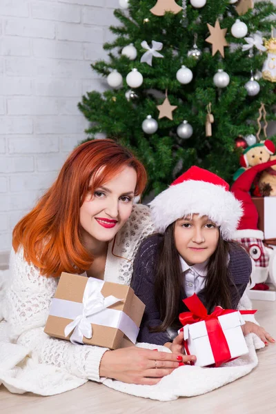 ギフトボックスとクリスマスツリーを持つ若い幸せな母親と小さな娘 — ストック写真