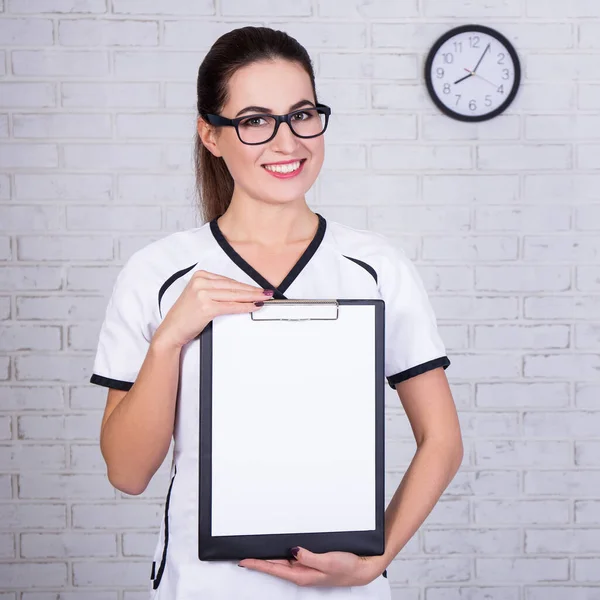 Mujer Médico Enfermera Sujetando Portapapeles Con Papel Blanco Sobre Pared —  Fotos de Stock