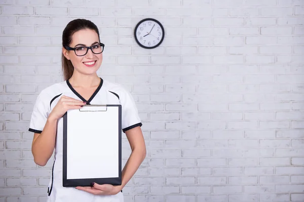 Joven Doctora Enfermera Sujetando Portapapeles Con Papel Blanco Sobre Pared — Foto de Stock