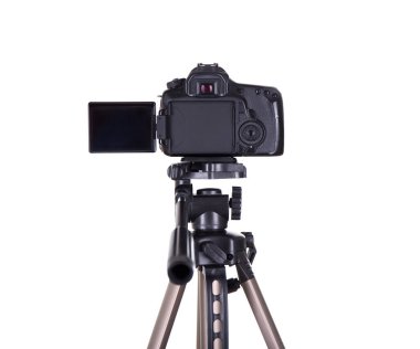 Fotoğraf ve video konsepti - beyaz arkaplanda izole edilmiş tripoda boş ekran ile modern dslr kameranın dikey görünümü