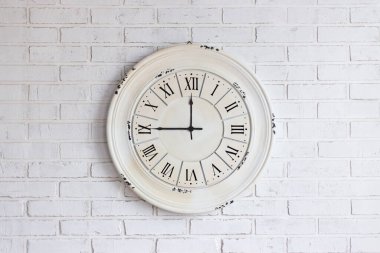 Beyaz tuğlalı duvarda eski bir saat