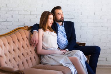 İlişki ve aşk kavramı. Genç ve güzel bir çift oturup bir şeyin hayalini kuruyor.