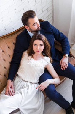 İlişki, aşk ve cazibe kavramı. Güzel bir çift eski moda koltukta oturuyor.