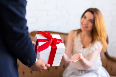 Tatil konsepti. Erkek, sürpriz kız arkadaşına ya da karısına hediye kutusu veriyor.