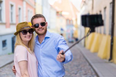 Mutlu turistler akıllı telefondan selfie çekiyorlar.