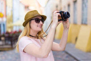 seyahat ve fotoğraf konsepti - genç bayan turist retro kamerayla fotoğraf çekiyor