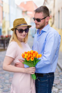 seyahat ve aşk kavramı - genç bir adam kız arkadaşına ya da karısına çiçek veriyor
