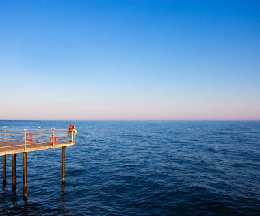 seyahat ve tatil konsepti - mavi denizde ahşap iskele