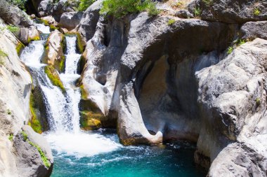 Turkuaz suyu ve güzel şelalesi olan dağ nehri