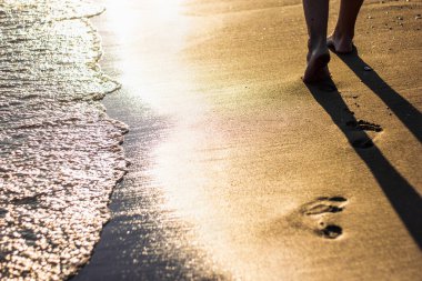 Plaj seyahati konsepti - sahildeki ayak izlerine yakın çekim