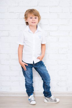Beyaz arka planda poz veren sevimli küçük çocuk.