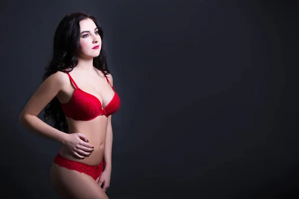 性感年轻漂亮女人的画像 穿着红色蕾丝内衣裤 黑色背景上有空隙 — 图库照片