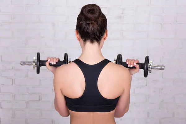 Achteraanzicht Van Vrouw Doen Oefeningen Met Halters Witte Bakstenen Muur — Stockfoto