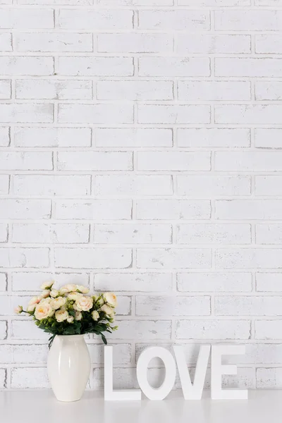 Beyaz Ahşap Kelime Aşk Çiçekler Beyaz Tuğla Duvar Arkasında — Stok fotoğraf