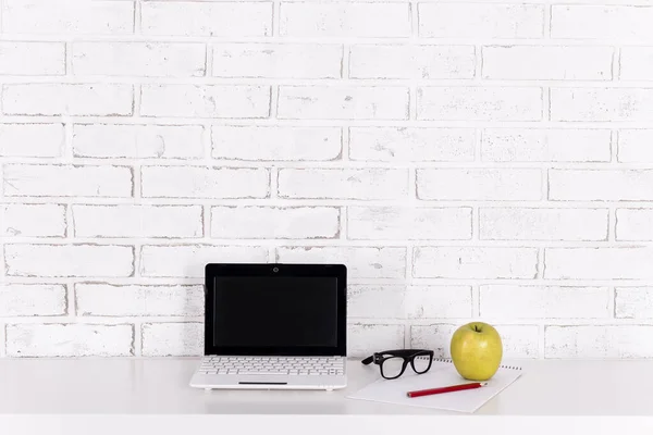 自宅やオフィスでの職場 レンガの壁の上のテーブルの上に白い現代のラップトップ — ストック写真