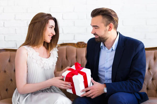 愛と休日のコンセプト ハンサムな男は彼のガールフレンドにギフトボックスを与える — ストック写真