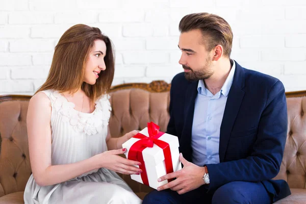 バレンタインデーまたはクリスマスのコンセプト 若いですハンサムな男与えギフトボックスに彼のガールフレンド — ストック写真
