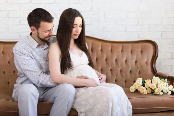 Jovem Casal Feliz Esperando Bebê Sentado Casa — Fotografia de Stock