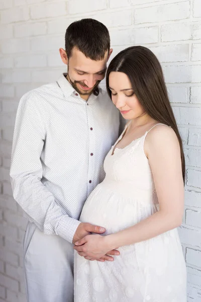 Aile Hamilelik Ebeveynlik Kavramı Beyaz Tuğla Duvarın Üzerinde Poz Veren — Stok fotoğraf