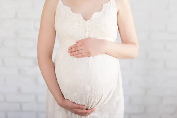 Hamilelik Konsepti Hamile Karnının Beyaz Tuğla Duvarın Üzerine Kapatılması — Stok fotoğraf