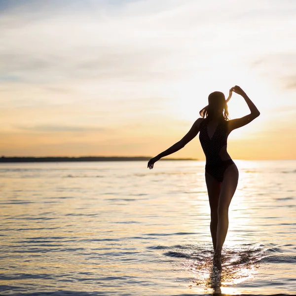 Gün Batımında Plajda Yürüyen Bikinili Seksi Bir Kadının Silueti — Stok fotoğraf