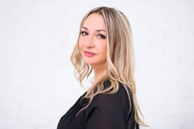 Beyaz arka planda poz veren orta yaşlı güzel bir kadın