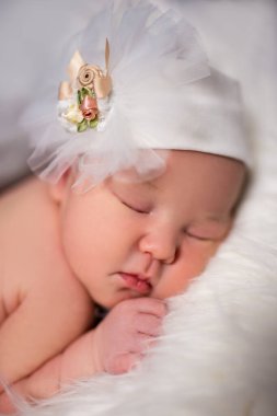Beyaz şapkalı, çiçekli, tatlı, uyuyan bebeğe yaklaş.