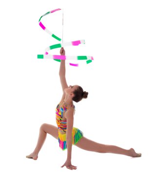 Güzel zayıf kadın beyaz arka planda izole edilmiş kurdeleyle jimnastik yapıyor.