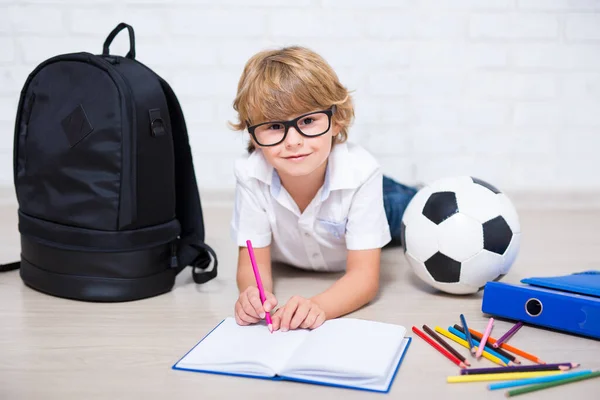 Schattig Klein Schooljongetje Bril Doen Huiswerk Liggend Vloer — Stockfoto