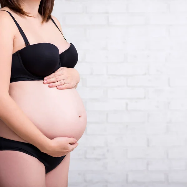 Närbild Magen Gravid Kvinna Underkläder Över Vit Tegelvägg — Stockfoto