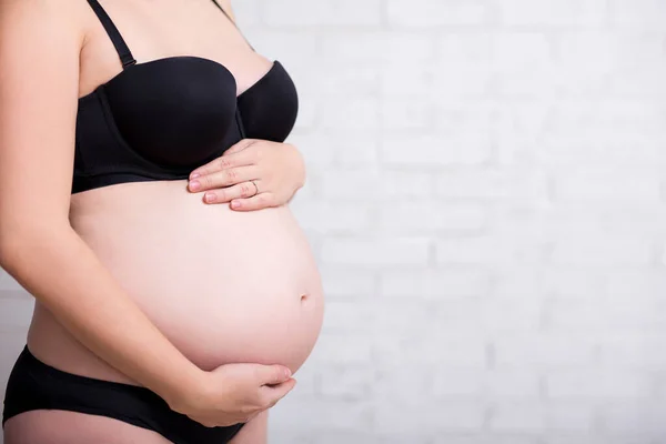 Sidovy Närbild Magen Gravid Kvinna Svart Underkläder Över Vit Vägg — Stockfoto