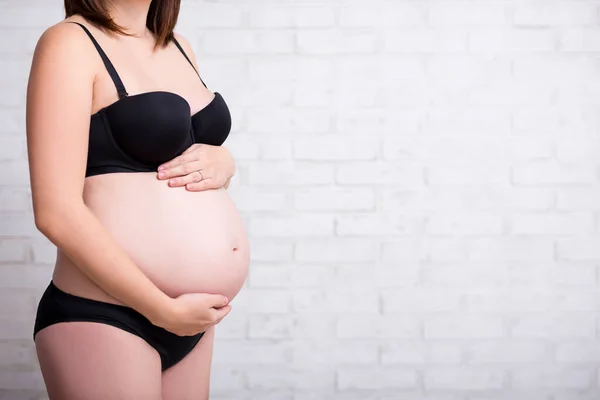 Närbild Gravid Kvinna Underkläder Röra Hennes Mage Över Vit Tegelvägg — Stockfoto