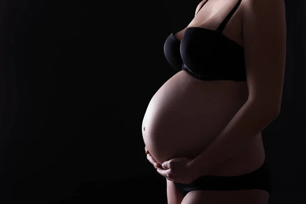 怀孕的腹部和黑色背景上的复制空间 — 图库照片