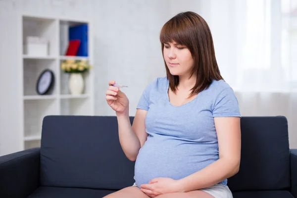 Schwangerschafts Und Krankheitskonzept Schwangere Sitzt Auf Sofa Mit Thermometer Wohnzimmer — Stockfoto