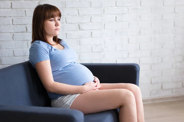 Junge Schöne Schwangere Frau Sitzt Auf Sofa Wohnzimmer Über Ziegelwand — Stockfoto