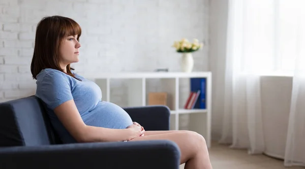 Nachdenkliche Schwangere Sitzt Auf Sofa Modernen Wohnzimmer — Stockfoto