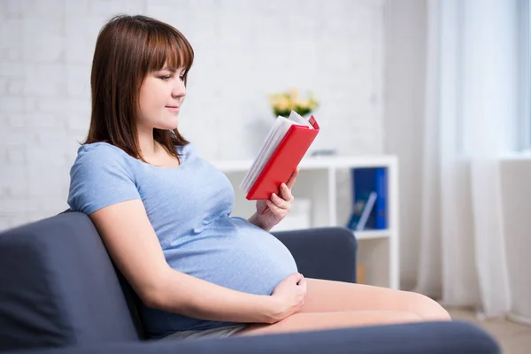 Jonge Zwangere Vrouw Lezen Boek Moderne Woonkamer — Stockfoto