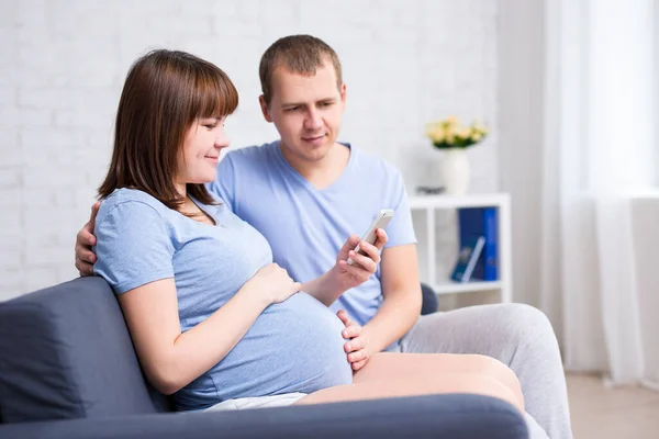 Ung Vacker Gravid Par Ser Något Smart Telefon Modernt Vardagsrum — Stockfoto