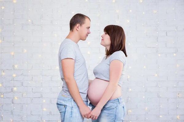 Side View Happy Pregnant Couple Standing White Brick Wall Christmas Royalty Free Stock Photos